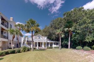 ein weißes Haus mit Palmen im Hof in der Unterkunft You are my Sunshine - 4213 Fifth Street in Saint Simons Island