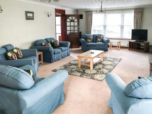 a living room with blue couches and a coffee table at Lyndhurst in Ely