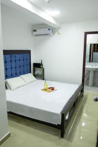 Un dormitorio con una cama con un plato de comida. en HOTEL SEAHORSE AYANGUE, en Ayangue