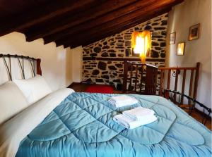 Un dormitorio con una cama azul con toallas. en Μaisonette Mary en Palaios Agios Athanasios