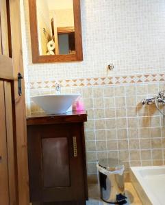 uma casa de banho com um lavatório e um espelho em Μaisonette Mary em Palaios Agios Athanasios