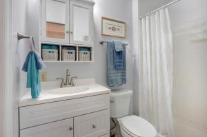 ein weißes Badezimmer mit Waschbecken und Toilette in der Unterkunft EZBreezy - 4217 Fifth Street in Saint Simons Island + 20 Fotos