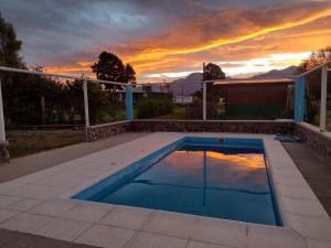 una piscina con puesta de sol en el fondo en Cabañas Rosa en La Aldea