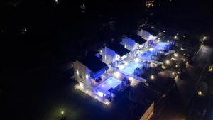 an overhead view of a house at night with blue lights at White Pearl in Pefkochori