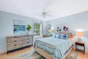 ein Schlafzimmer mit einem Bett, einer Kommode und einem Fenster in der Unterkunft Sunny Dayz - 4 bedrooms 1122 & 1124 Park in Demere Park