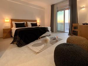 a bedroom with a large bed and a balcony at Calistus Mykonos in Mikonos