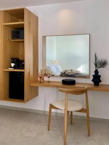 a room with a desk with a mirror and a chair at Calistus Mykonos in Mikonos