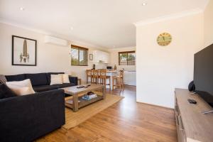 a living room with a couch and a table at Sunbaker Pet Friendly Awards Finalist 4 Mins Walk to Culburra Beach in Culburra Beach