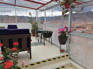 a balcony with a table and chairs and flowers at Suyay B&B in Cusco
