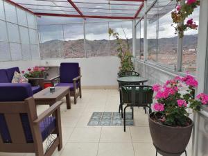un balcón con mesas, sillas y flores en Suyay B&B, en Cusco