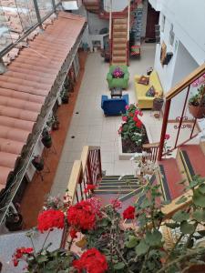 vistas a un patio con flores rojas y escaleras en Suyay B&B en Cuzco