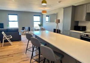 cocina y sala de estar con barra y sillas en Margate Seaside Penthouse With Sea views Sleeps 6 en Kent