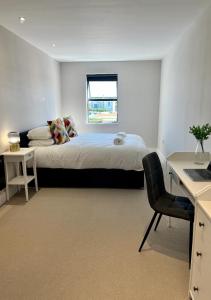 um quarto com uma cama, uma secretária e uma cadeira em Margate Seaside Penthouse With Sea views Sleeps 6 em Kent