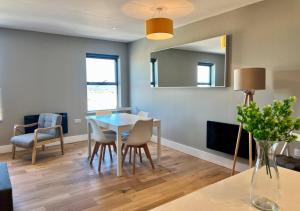 uma sala de jantar com uma mesa, cadeiras e um espelho em Margate Seaside Penthouse With Sea views Sleeps 6 em Kent