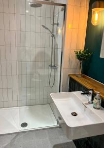 baño blanco con ducha y lavamanos en Margate Seaside Penthouse With Sea views Sleeps 6 en Kent