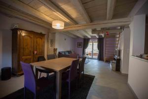 una sala da pranzo con tavolo in legno e sedie viola di La grange de Sophie a Berstett