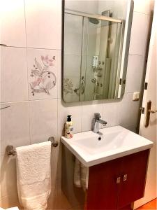 W łazience znajduje się umywalka i lustro. w obiekcie Piso Cuatro Caminos w mieście A Coruña