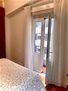 a bedroom with a bed and a large window at Piso Cuatro Caminos in A Coruña