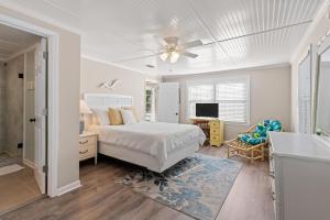 ein Schlafzimmer mit einem Bett und einem Deckenventilator in der Unterkunft Byrd's Nest - 1107 Beachview Drive in Demere Park