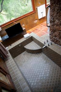 Nirvana Restaurant & Retreat في سان ميغيل دي الليندي: حمام مع دش مع أرضية من البلاط