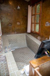 ein Bad mit einer Dusche und Fliesenboden in der Unterkunft Nirvana Restaurant & Retreat in San Miguel de Allende