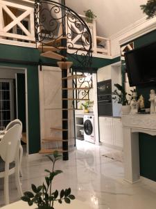 a kitchen with green and white walls and a spiral staircase at Domek w Pieninach Apartament Pałacowy Liliana in Krościenko