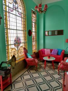 uma sala de estar com mobiliário vermelho e paredes verdes em Casa Reina Palermo Queens em Buenos Aires