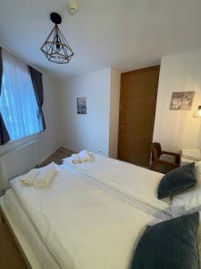 a large white bed in a room with a window at Olimpijska kuća A307 in Jahorina