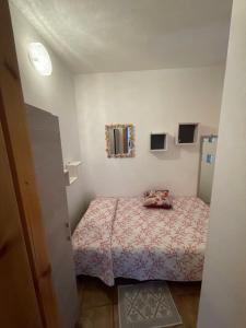 - une petite chambre avec un lit et un miroir dans l'établissement Le Onde, à Torre Dei Corsari