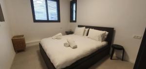 een slaapkamer met een bed met handdoeken erop bij The Huge by HolyGuest in Tel Aviv