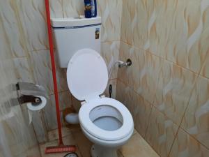 a bathroom with a toilet with a red mop at Sweet Memories Haven in Kikuyu