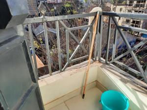 a mop leaning against a metal railing on a balcony at Sweet Memories Haven in Kikuyu