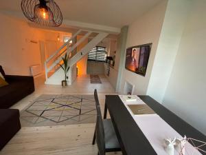 ein Wohnzimmer mit einem Tisch und einer Treppe in der Unterkunft Milan House in London