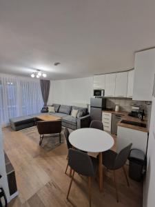 a kitchen and living room with a table and chairs at Olimpijska kuća A307 in Jahorina