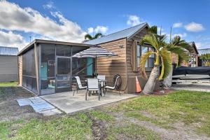 una casa con mesa, sillas y una palmera en Everglades City Cabin Dock and Heated Pool!, en Everglades
