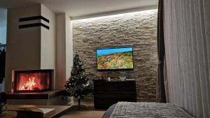 a room with a fireplace and a tv on a brick wall at Olimpijska kuća A307 in Jahorina