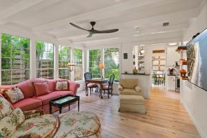 a living room with a pink couch and a table at Endless Summer - 4217 - 6th Street in Saint Simons Island