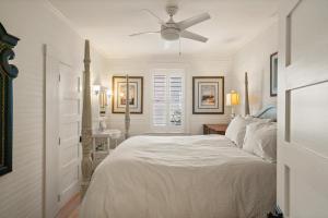 a white bedroom with a bed and a ceiling fan at Endless Summer - 4217 - 6th Street in Saint Simons Island +20 photos