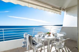 stół i krzesła na balkonie z widokiem na ocean w obiekcie PANORAMIC SEA VIEW Apartment in the Mourré Rouge area of Cannes w Cannes