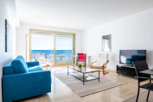 salon z niebieską kanapą i telewizorem w obiekcie PANORAMIC SEA VIEW Apartment in the Mourré Rouge area of Cannes w Cannes