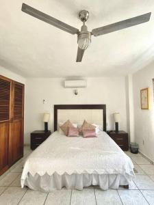 a bedroom with a bed with a ceiling fan at Casa con Piscina Cerca de playa in Nuevo Vallarta
