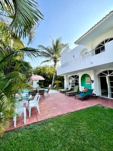 a house with a patio with chairs and tables at Casa con Piscina Cerca de playa in Nuevo Vallarta