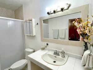 a bathroom with a sink and a toilet and a mirror at Casa con Piscina Cerca de playa in Nuevo Vallarta +26 photos