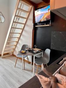 um quarto com uma mesa e cadeiras e uma televisão em Pont Achard #2-T1bis-Mezzanine -5mnGare- Poitiers em Poitiers