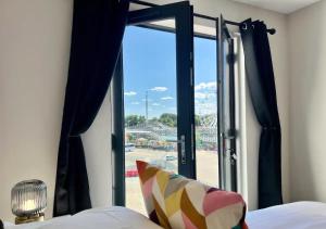 a bedroom with a window with a view of a stadium at Beachfront Bliss Margate With Sea Views Sleeps 7 in Kent
