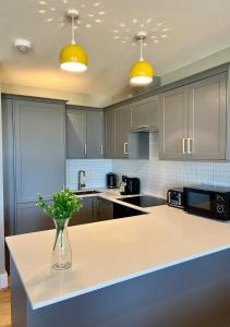 a kitchen with a vase of flowers on a counter at Beachfront Bliss Margate With Sea Views Sleeps 7 in Kent