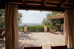 vistas a un patio con sillas y sombrilla en Il casale tra le vigne e il mare en Tollo