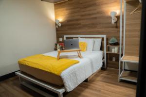 1 dormitorio con 1 cama con ordenador portátil en Amsterdam Hostel, en San Francisco