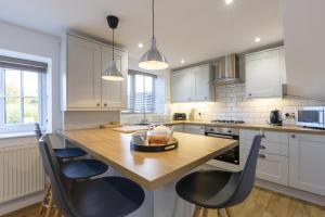 cocina con mesa de madera y sillas negras en Stable Cottage, en Whitby