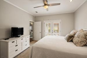 ein Schlafzimmer mit einem Bett und einem Flachbildfernseher in der Unterkunft Village Retreat - 100 Mews Circle in King City